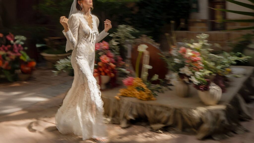 Bride walking beside a traditional Sofreh Aghd during a Persian wedding ceremony