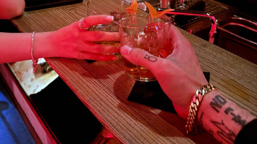 Two people raising cocktails in a toast during a date, celebrating connection and a promising start