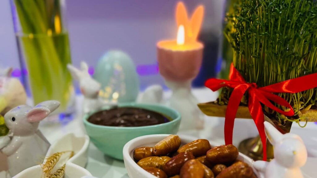 Close-up of a traditional Haft-Seen table with Sabzeh, Senjed, candles, and Persian New Year decorations celebrating Nowruz among the Iranian diaspora in Germany