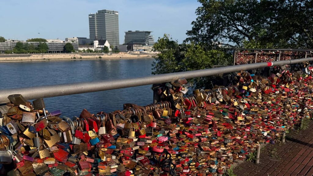 Love locks attached to a riverside bridge overlooking the city, symbolizing commitment and meaningful connections