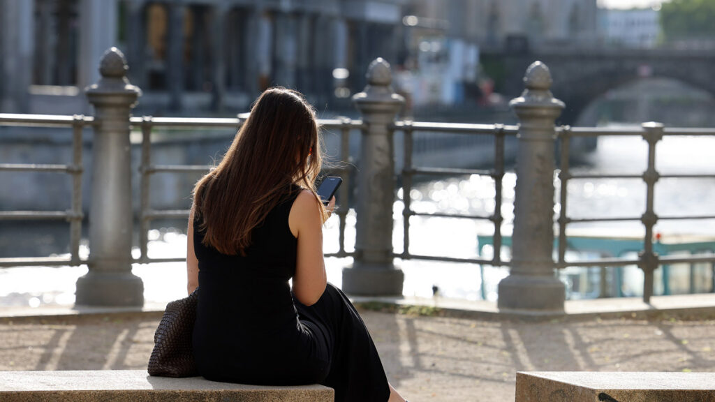 Persian woman alone in Germany looking at her phone
