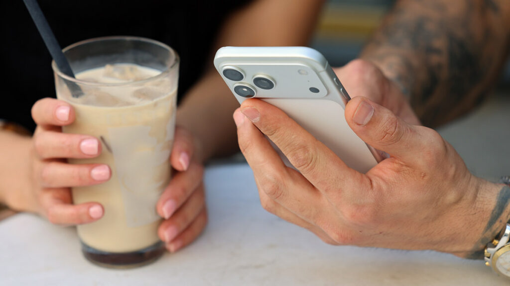 Two people using a smartphone during a casual cafe meeting