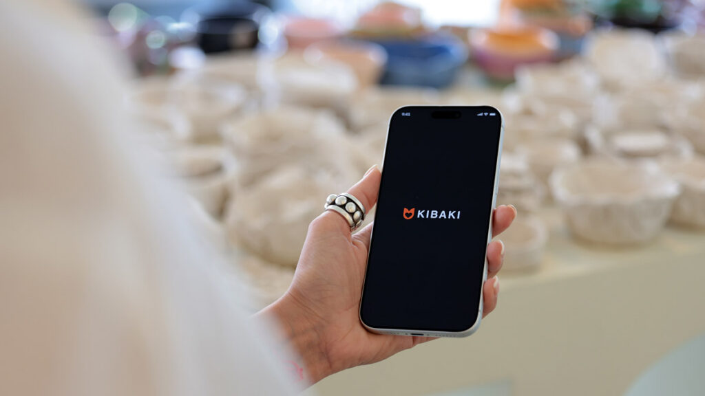 Person holding a smartphone displaying the Kibaki Iranian dating app