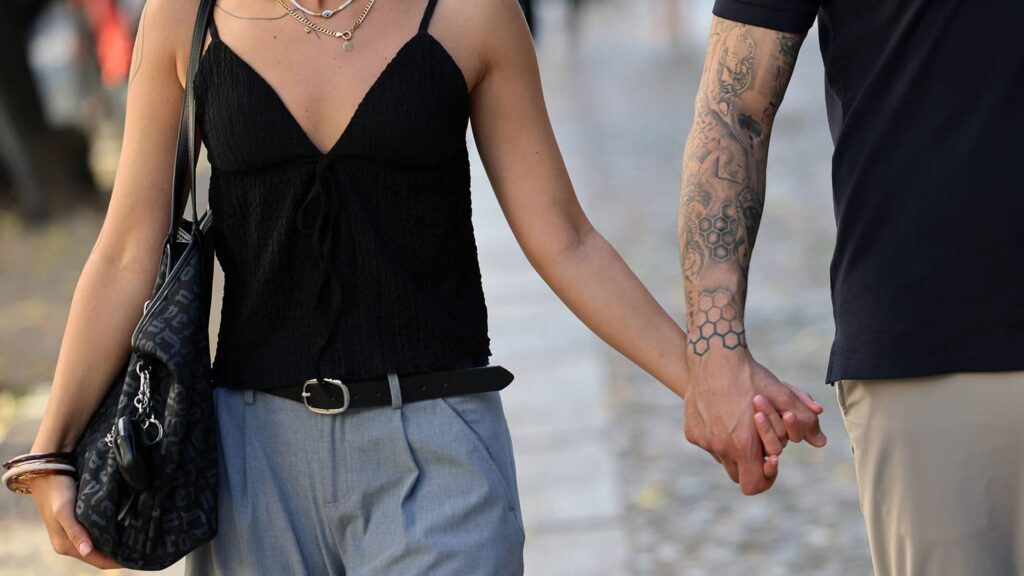 Couple holding hands while walking together in a European city