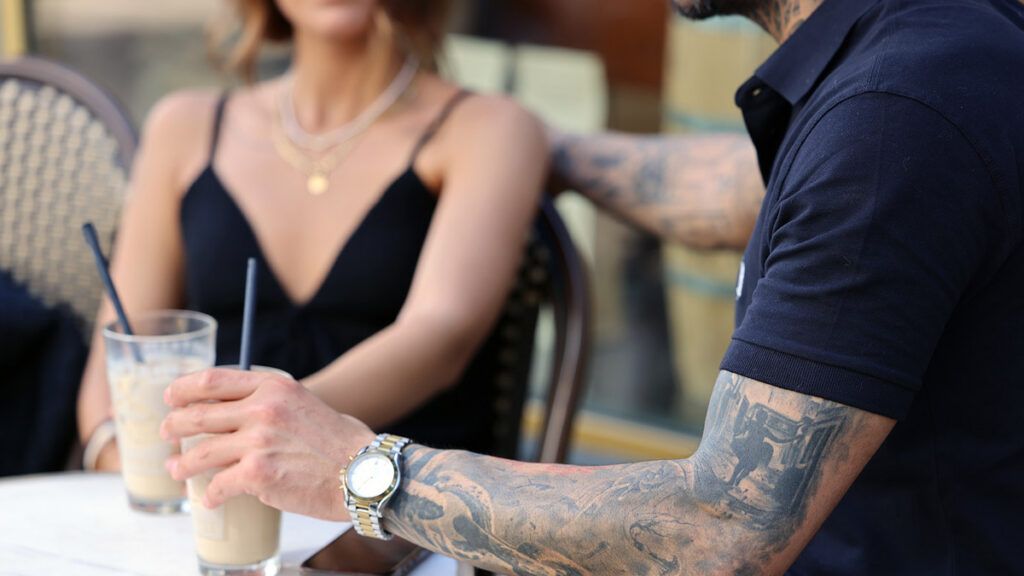 Iranian couple talking over coffee during a casual first date at a café in Düsseldorf