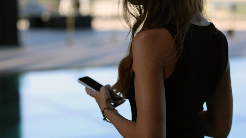 Woman using a smartphone for online dating, representing Iranian singles in the US