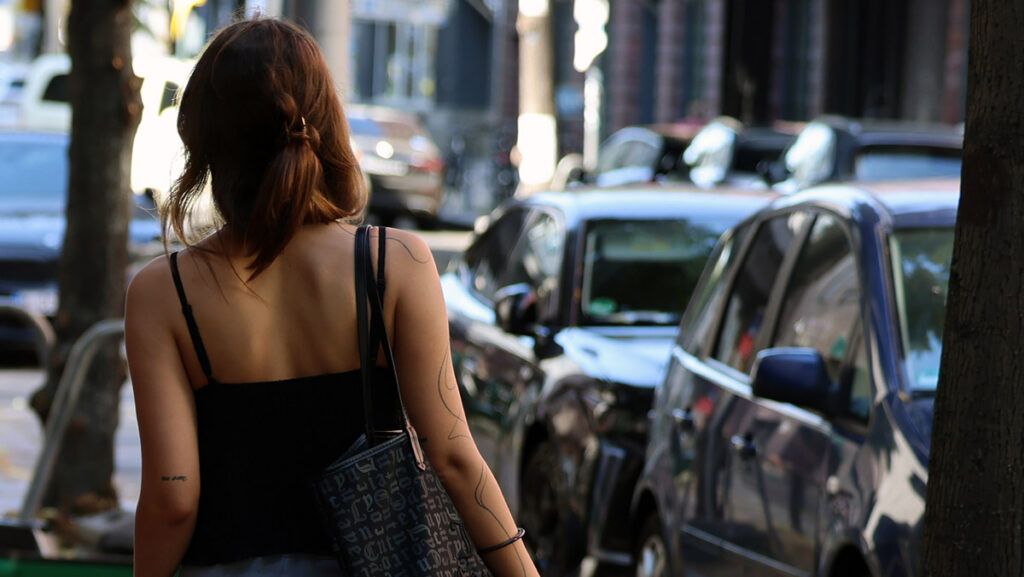 Young Iranian woman walking through a street in Düsseldorf, representing life, independence, and meeting new people