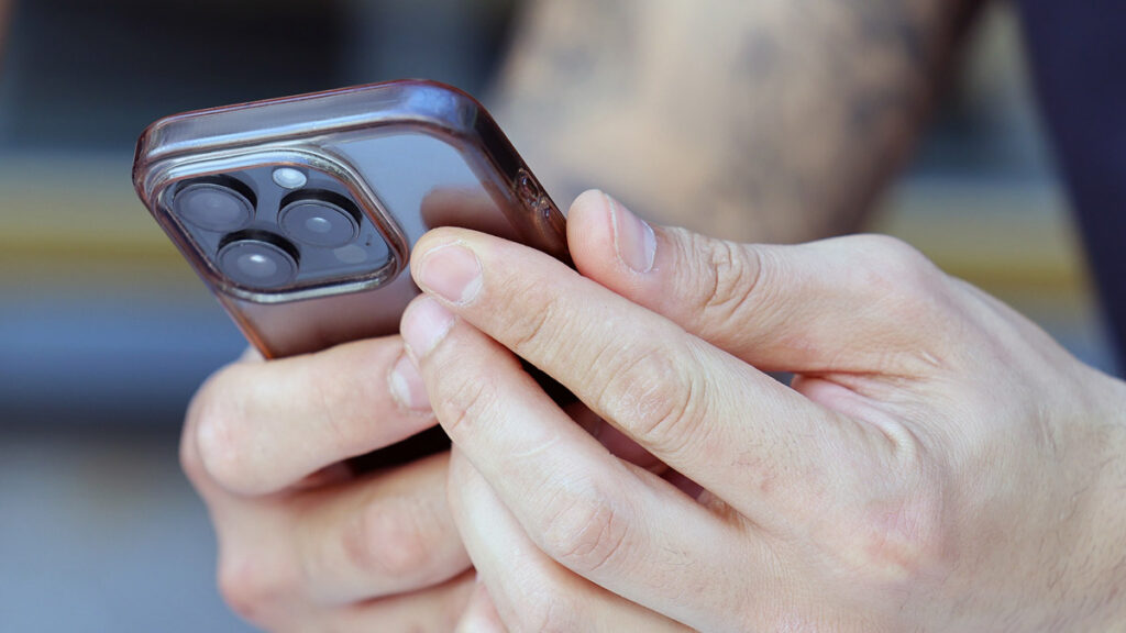 Close-up of a smartphone in hand, representing online dating and messaging for Iranians in Germany