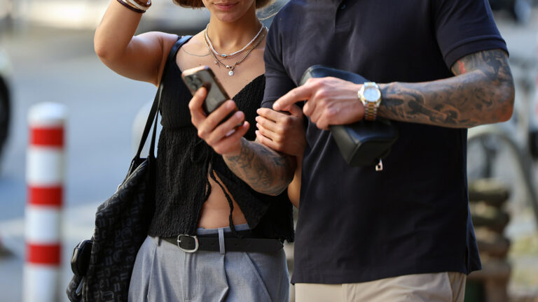 Couple walking together and looking at a phone in the city