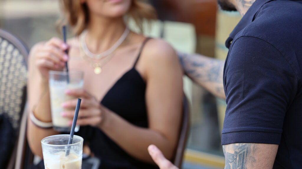 Zwei Menschen im Gespräch bei einem Getränk im Café