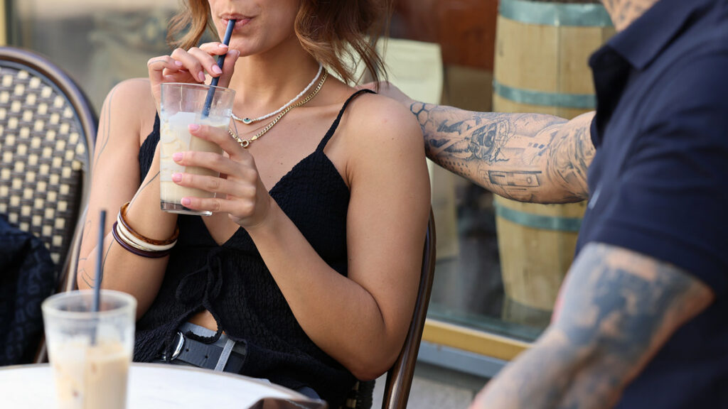 Paar sitzt im Café und hält Händchen über dem Tisch