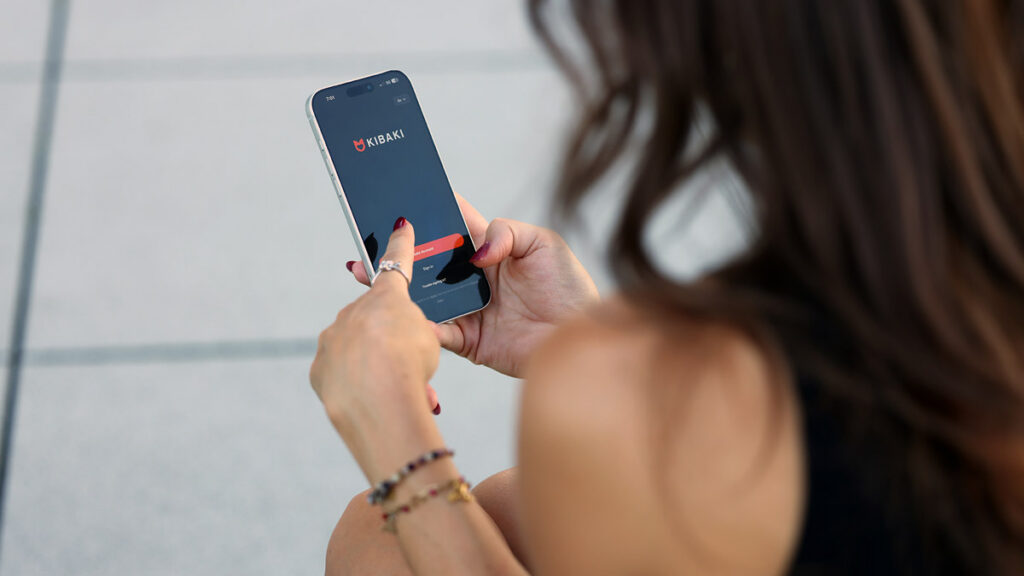 Woman opening the KIBAKI app to find Persian singles nearby
