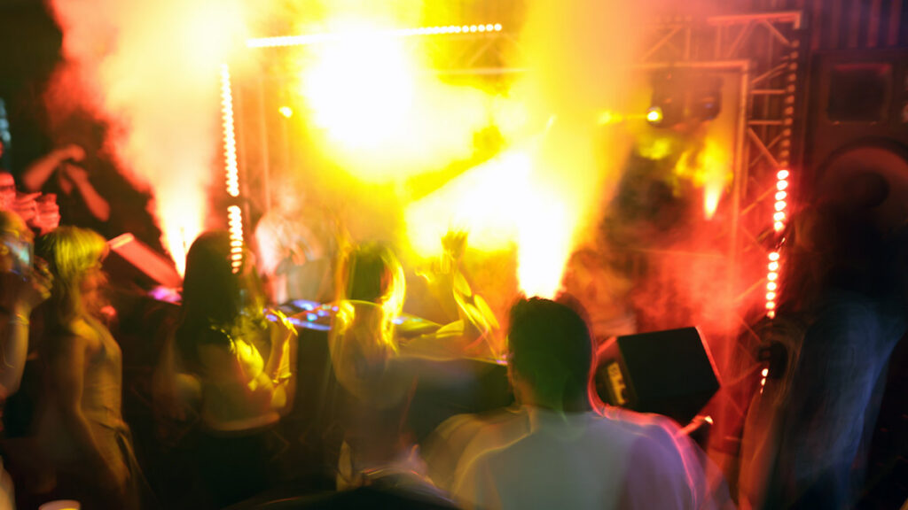Crowd at a Persian concert with stage lights and music